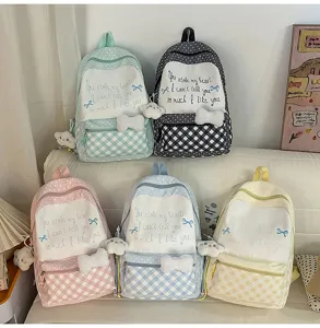 Süßer karierter Schulrucksack in verschiedenen Farben mit süßer Schleife und Plüschanhänger.