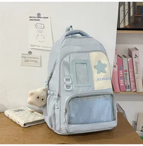 Détail de sac à dos d'étudiant bleu clair avec joli patch étoile et poche filet sur le bureau.