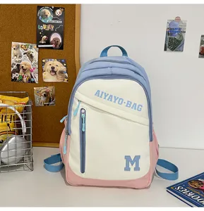 Nahaufnahme des farbblockierten Studentenrucksacks mit Fronttasche und Buchstabenprint.