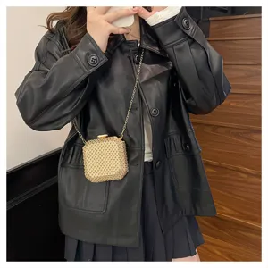 Primo piano della mini borsa a catena con strass scintillanti indossata come dettaglio.