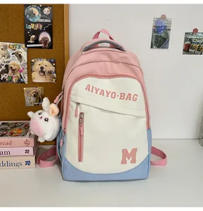 Detailansicht des rosa-weißen Studentenrucksacks mit niedlichem Hasenanhänger und Tasche.