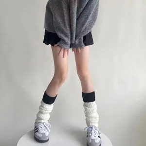 Detailopname van zwart-witte gebreide beenwarmers voor winterlaarzen in de herfst