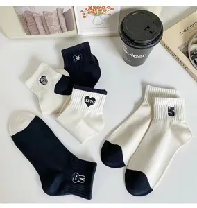 Close-up detail of chic black and white fashion ankle socks with cute embroidery.