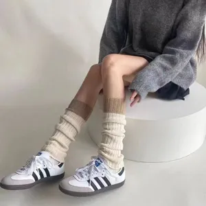 Gebreide beenwarmers in grijs en crème, gestyled met sneakers voor een warme winterse look