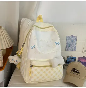 Süßes gelbes Kariertes Rucksack Detail mit Plüsch Anhänger und süßen gestickten Sprüchen.