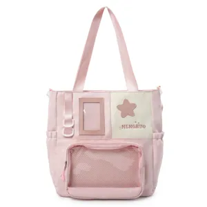 Vue détaillée de sac cabas bandoulière rose en toile avec poche transparente et résille.