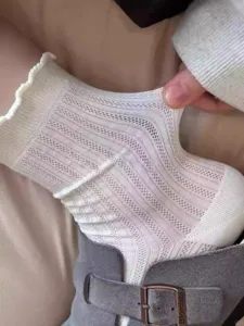Close-up detail of white mesh knit lace ruffles socks, breathable summer style stretchy.