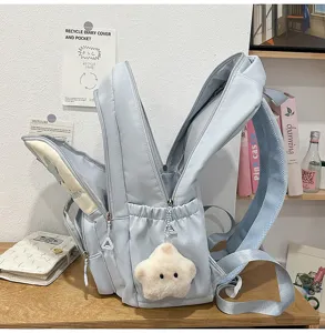 Vue détaillée du joli sac à dos d'école en toile bleu clair avec pendentif.