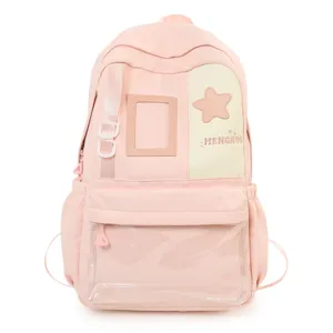 Detailed view of pink school backpack featuring clear front pocket, star patch and side storage.