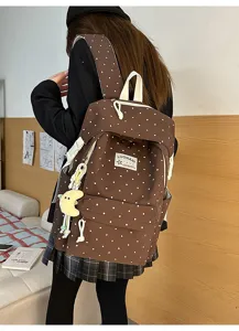 Brauner Rucksack mit Punkten Detailansicht weicher Stoff mit niedlichem Mond Anhänger.