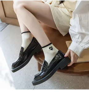 Detail view of fashion women's short socks with heart print paired with classic black shoes.