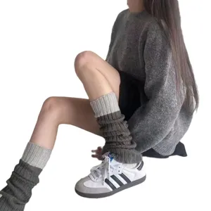Tweekleurige grijze gebreide beenwarmers voor dames, gedragen met sneakers en trui