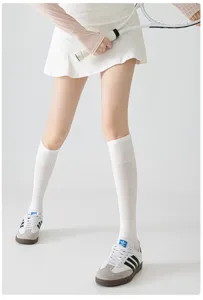 White compression sports knee high socks for women, breathable athletic gear for tennis running.