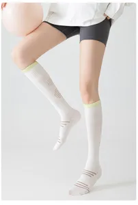 White sports compression knee high socks detail shot, thin breathable design for running fitness.