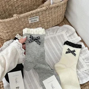 Close-up details of Korean ins style women cotton mid-calf socks with polka dot bow and ruffles.