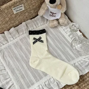 Korean style ins breathable cotton mid-tube socks featuring black and white polka dot bow and cuff.