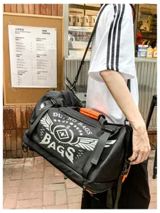 Vue détaillée d'un grand sac de sport noir avec bandoulière et logo graphique imprimé.