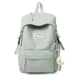 Hellgrüner Rucksack mit Pünktchen im Detail mit Fronttasche und süßem Mondanhänger.