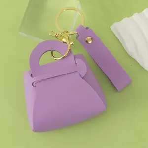 Cute purple leather mini handbag keychain coin purse with gold hardware and wrist strap.