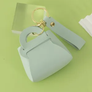Mint green leather mini handbag keychain with gold hardware and stylish strap charm.