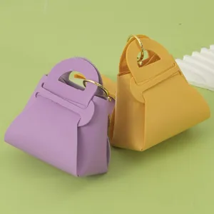 Close-up detail of cute mini leather handbag keychain, candy color coin purse accessory.