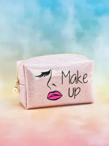 Glitter sequin makeup bag detail shot showing pink shiny surface, cute face art and pearl pull.