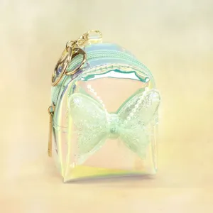 Holographic mini backpack coin purse with cute butterfly bow and keychain, perfect accessory.