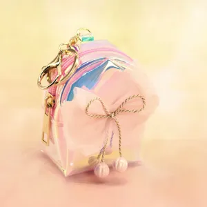 Detailed view of the iridescent mini backpack keychain with a cute pink mesh bow.