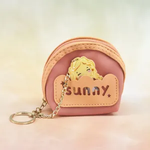 Close-up detail of cute mini pink coin purse keychain with character pendant and chain.
