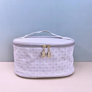 Detail view of stylish PU cosmetic bag, featuring woven pattern and gold zippers for travel.