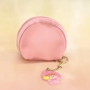 Mini pink round PVC coin purse with zipper closure, cute cartoon pendant and gold keychain.