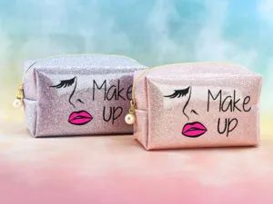 Glitter makeup bag detail showing sparkling sequin texture, pearl zipper pull and cute graphic.
