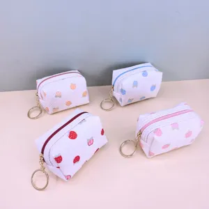 Compact waffle grid strawberry print coin purse and lipstick storage bag with a keychain.