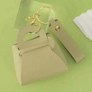 Mini leather handbag keychain in light green with gold hardware keyring and strap accessory.