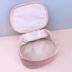 Detailed view of pink woven PU cosmetic bag interior, showing large capacity and lining.