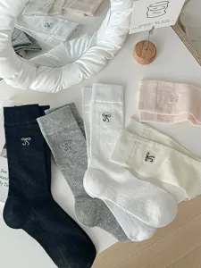 Detail shot of summer thin ballet style slouch socks featuring delicate embroidered bows on soft knit.