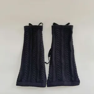 Detailed close-up of black cable knit leg warmers, soft cozy winter boot cuffs for women.