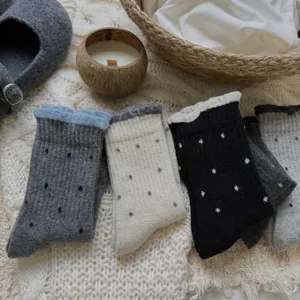 Cozy winter women polka dot mid-tube socks detail, cute ruffled edge knit socks on blanket.