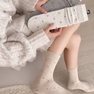 Close-up detail of women's sweet floral mid-tube socks, cozy knit texture, elegant autumn style.