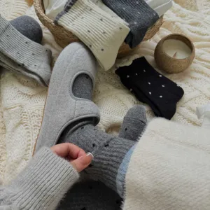 Close-up detail of cozy polka dot mid-calf cotton socks in warm knit lifestyle setting.