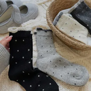 Detailed view of women's autumn winter polka dot cotton socks with cute ruffled lace cuffs.