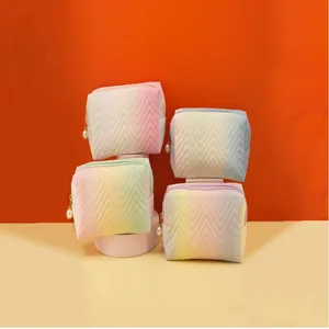 Detail view of the gradient chevron cosmetic bag with cute pearl zipper pull for daily use.