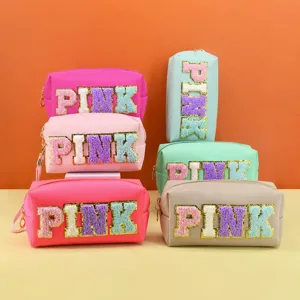 Fashionable PU leather cosmetic bag with cute embroidered letter design, portable travel makeup organizer.