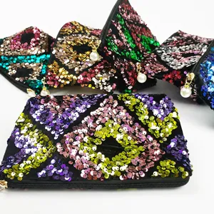 Details of sequin cosmetic pouch with geometric patterns and pearl zipper pull, elegant style.