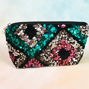 Close-up detail of colorful sequin cosmetic bag zipper and pearl pendant texture showcase.