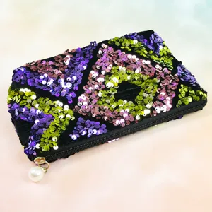 Detail view of the elegant black sequin cosmetic pouch with a cute pearl zipper pull design.