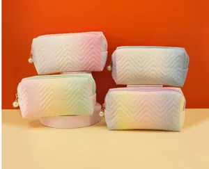 Gradient cosmetic bag detail showing quilted chevron design and elegant pearl zipper pull.