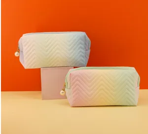 Detailed shot of pastel rainbow gradient quilted cosmetic bag with chic pearl zipper pull.