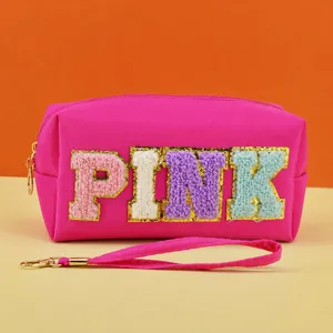 Pink cosmetic bag with colorful fuzzy letter patches, portable makeup pouch for daily use.