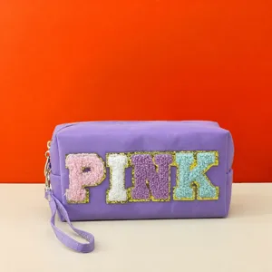 Purple cosmetic bag with colorful chenille letter patches, zipper closure and wrist strap.